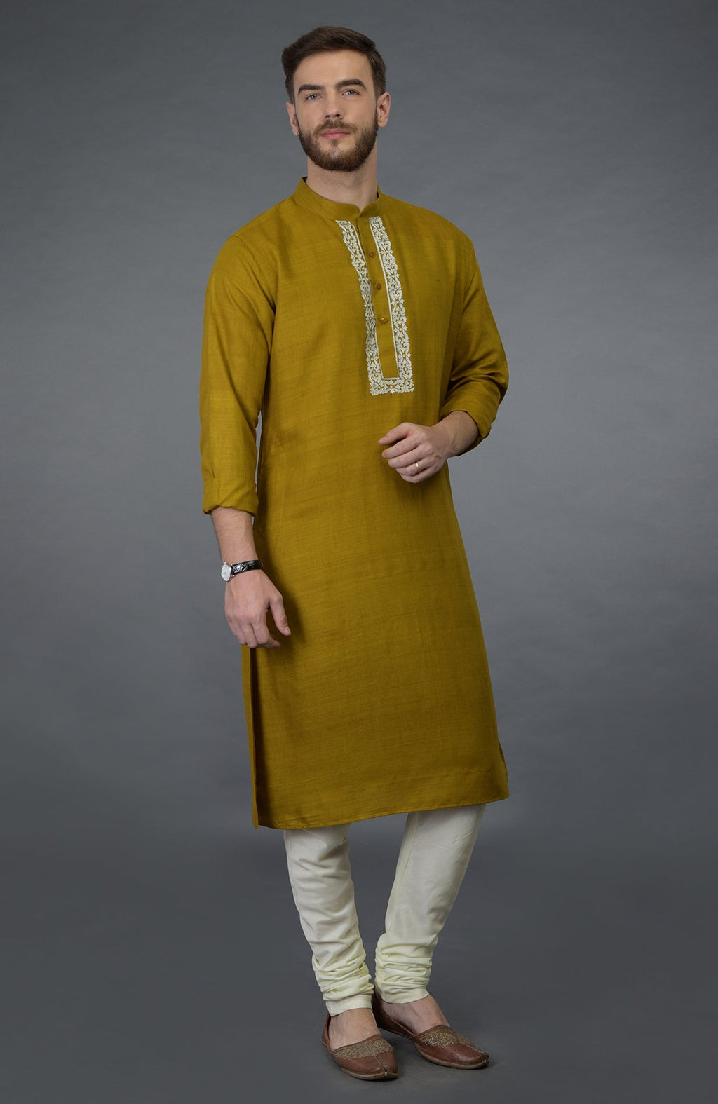 Mustard pure silk kurta with white embroidery, paired with ivory churidar and brown juttis.