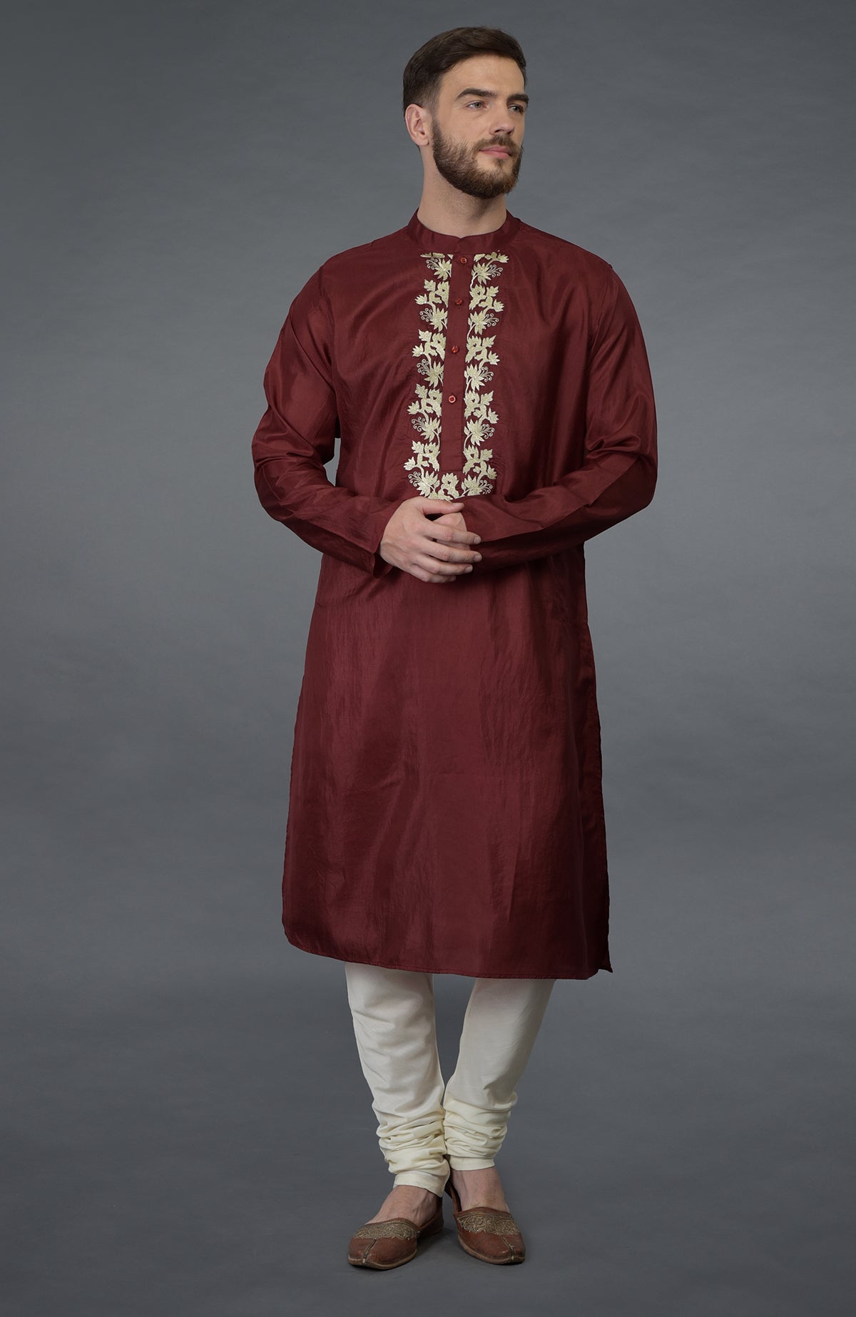 Burgundy silk kurta with gold tilla embroidery, paired with ivory churidar and brown juttis.
