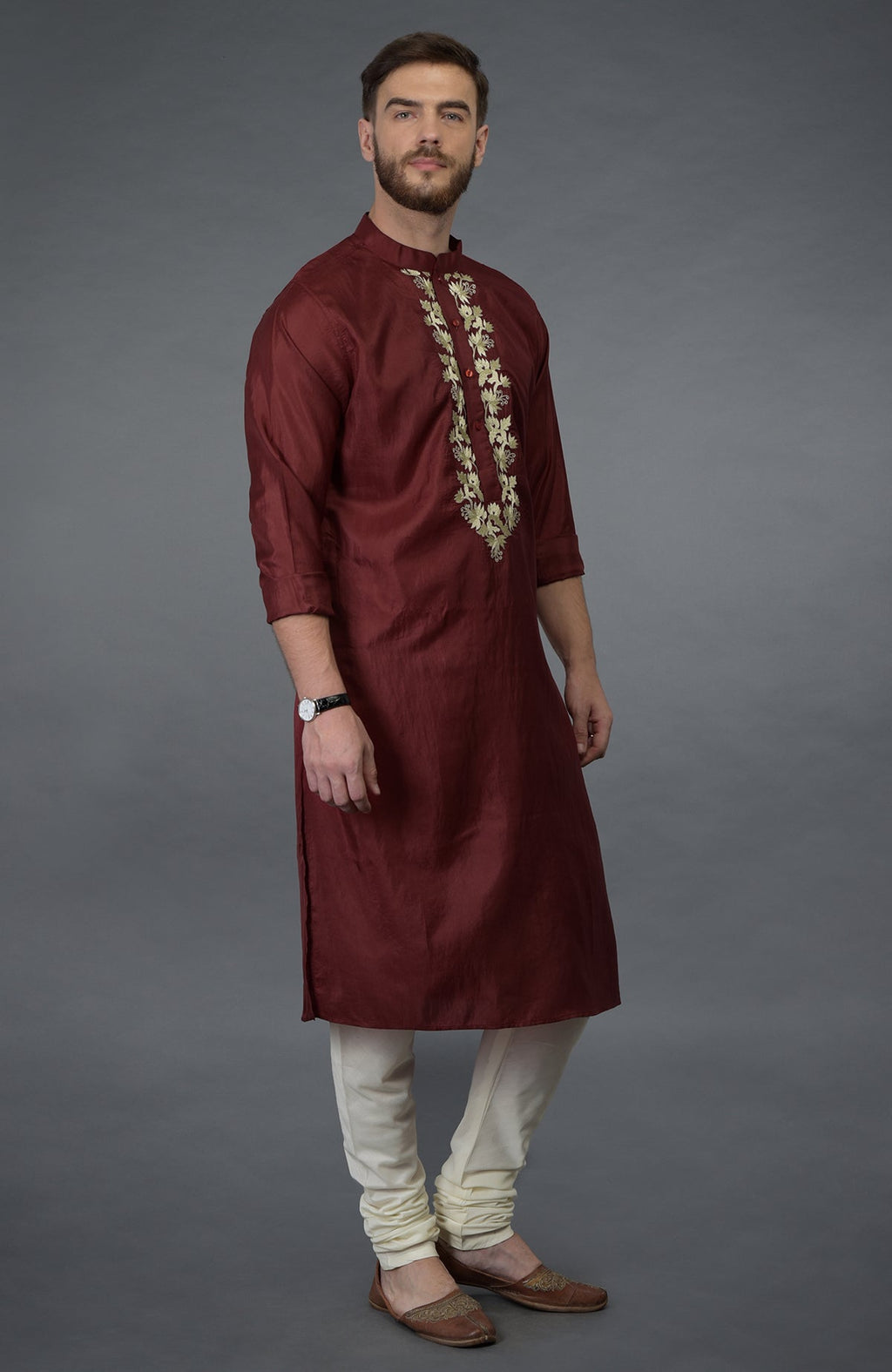 Burgundy silk kurta with gold tilla embroidery, paired with ivory churidar and brown juttis.