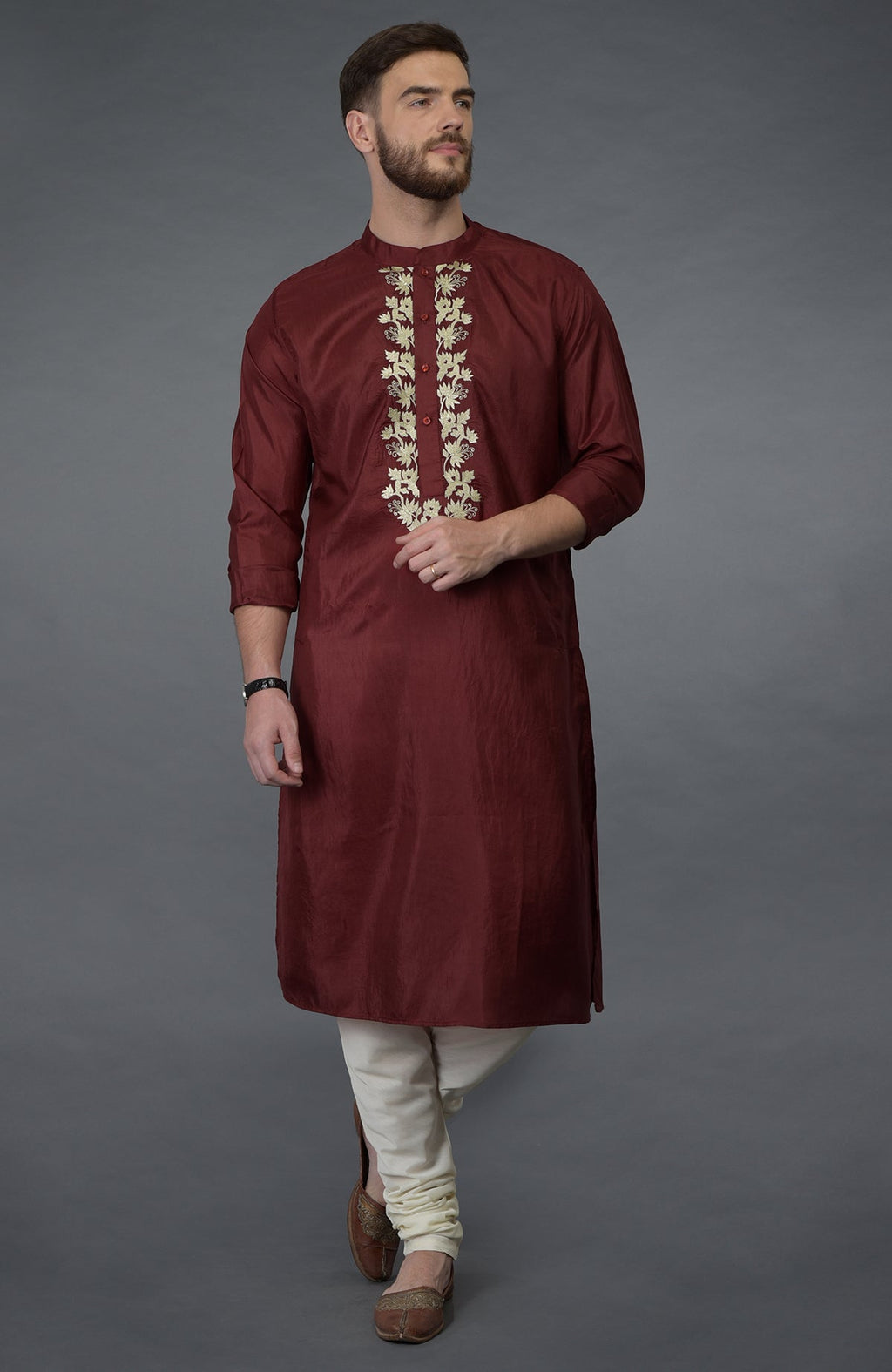 Burgundy silk kurta with gold tilla embroidery, paired with ivory churidar and brown juttis.