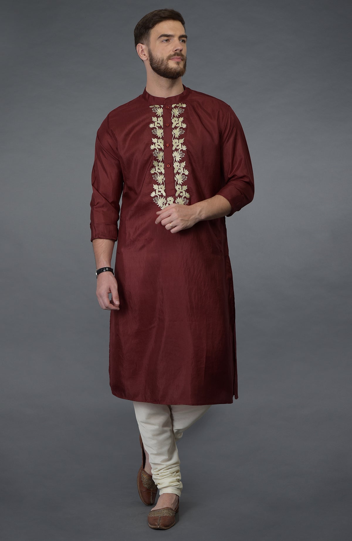 Burgundy silk kurta with gold tilla embroidery, paired with ivory churidar and brown juttis.