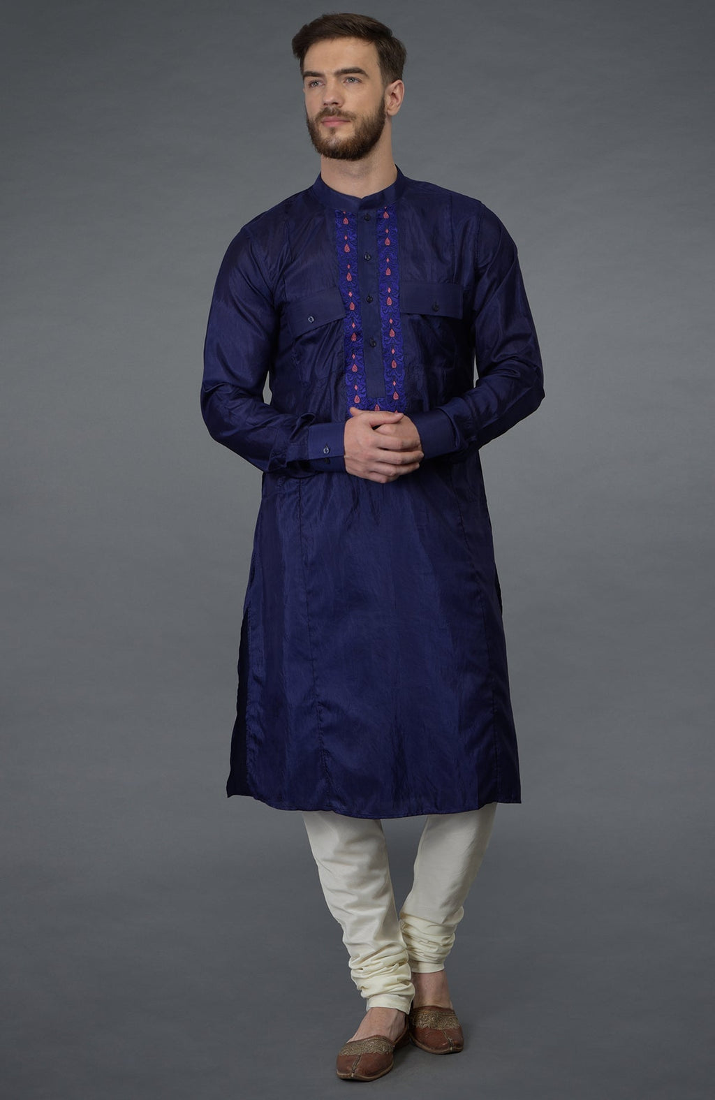 An ink blue embroidered silk kurta set with ivory churidar pajamas.