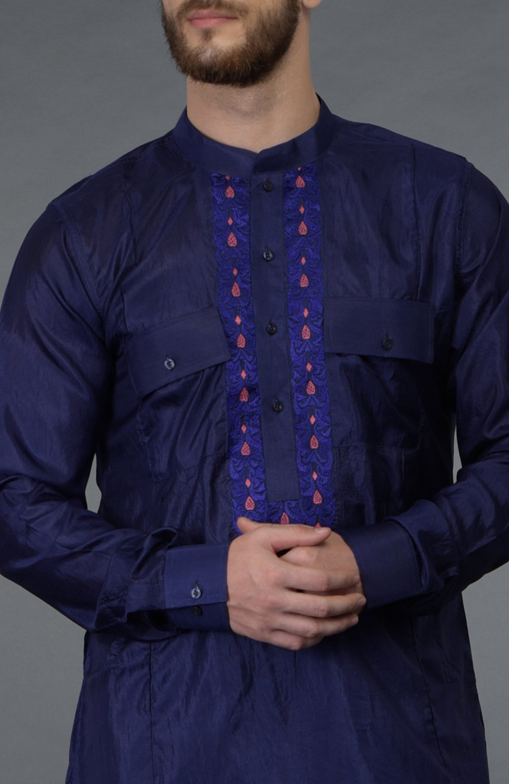 Ink blue silk kurta with embroidered placket detail, worn by a man.