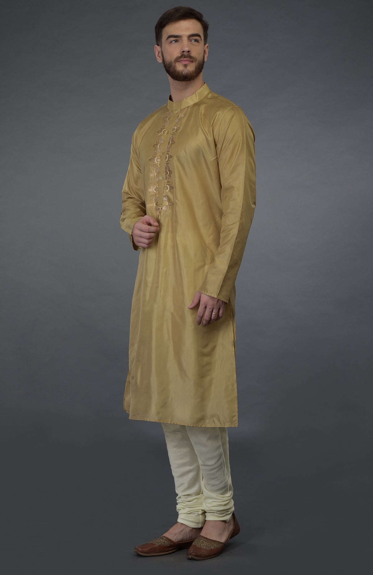 Gold silk kurta with floral embroidery and ivory churidar pants.