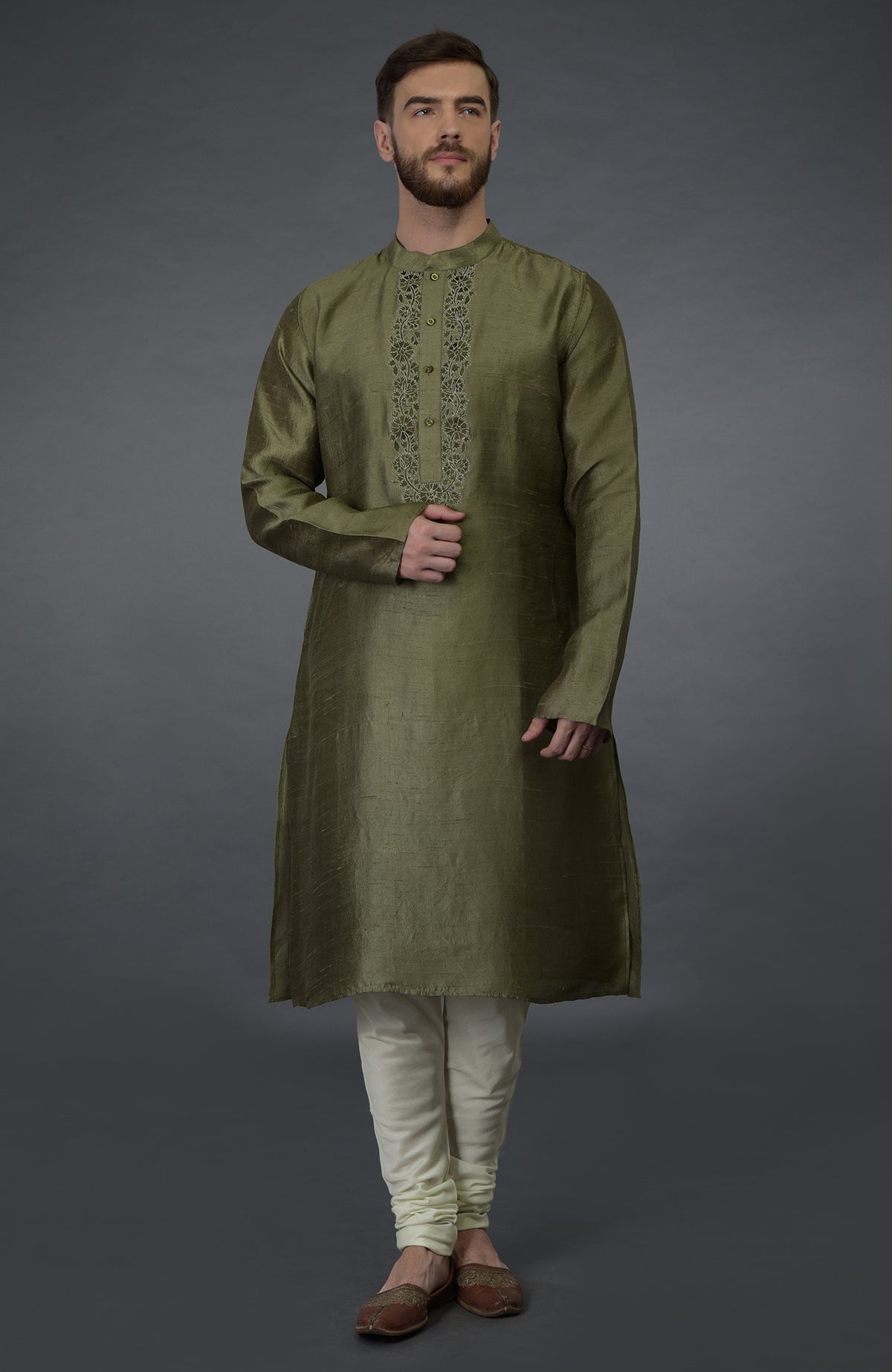 An olive green pure silk kurta with embroidered placket detail and ivory churidars.