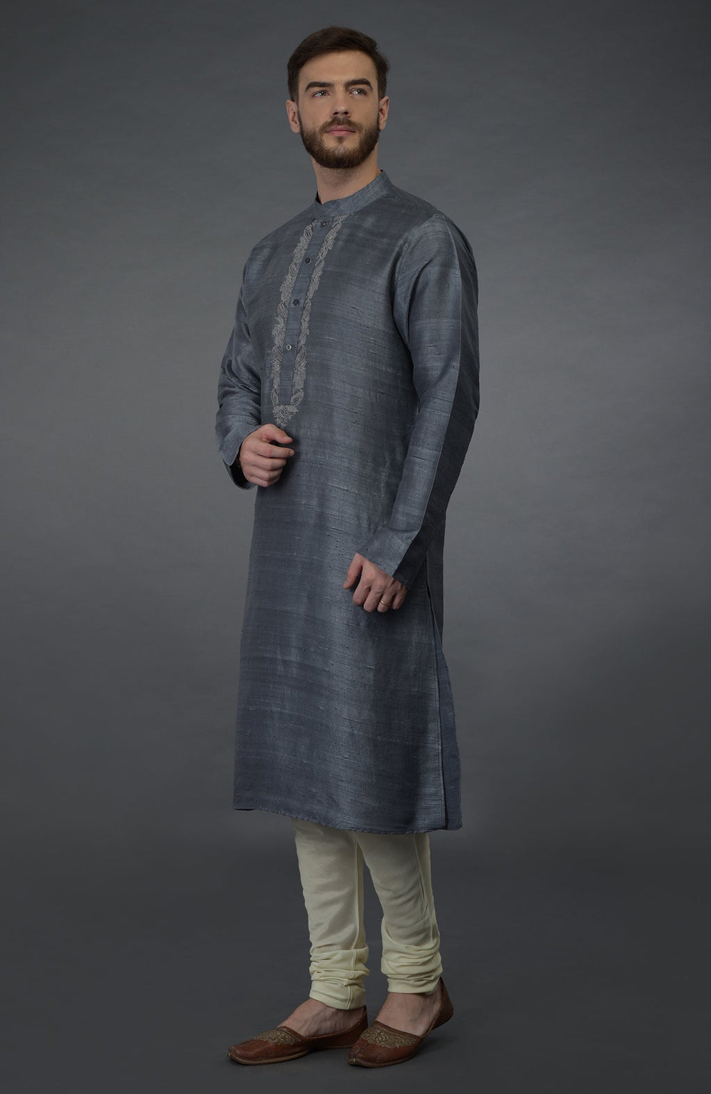 A man models a grey embroidered pure silk kurta set with ivory lowers.