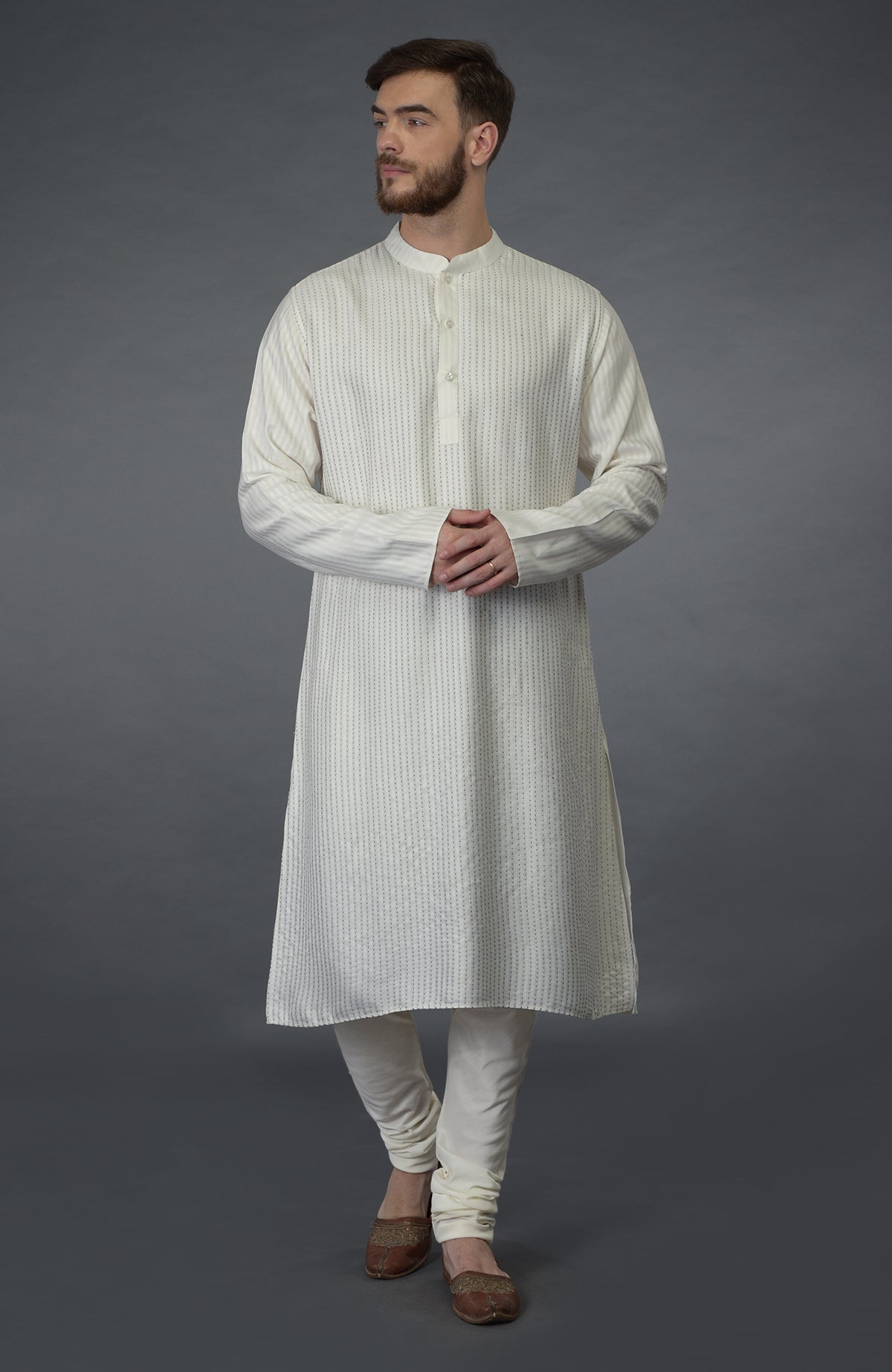 Ivory self weave and black Kantha striped silk kurta with matching churidar and brown juttis.
