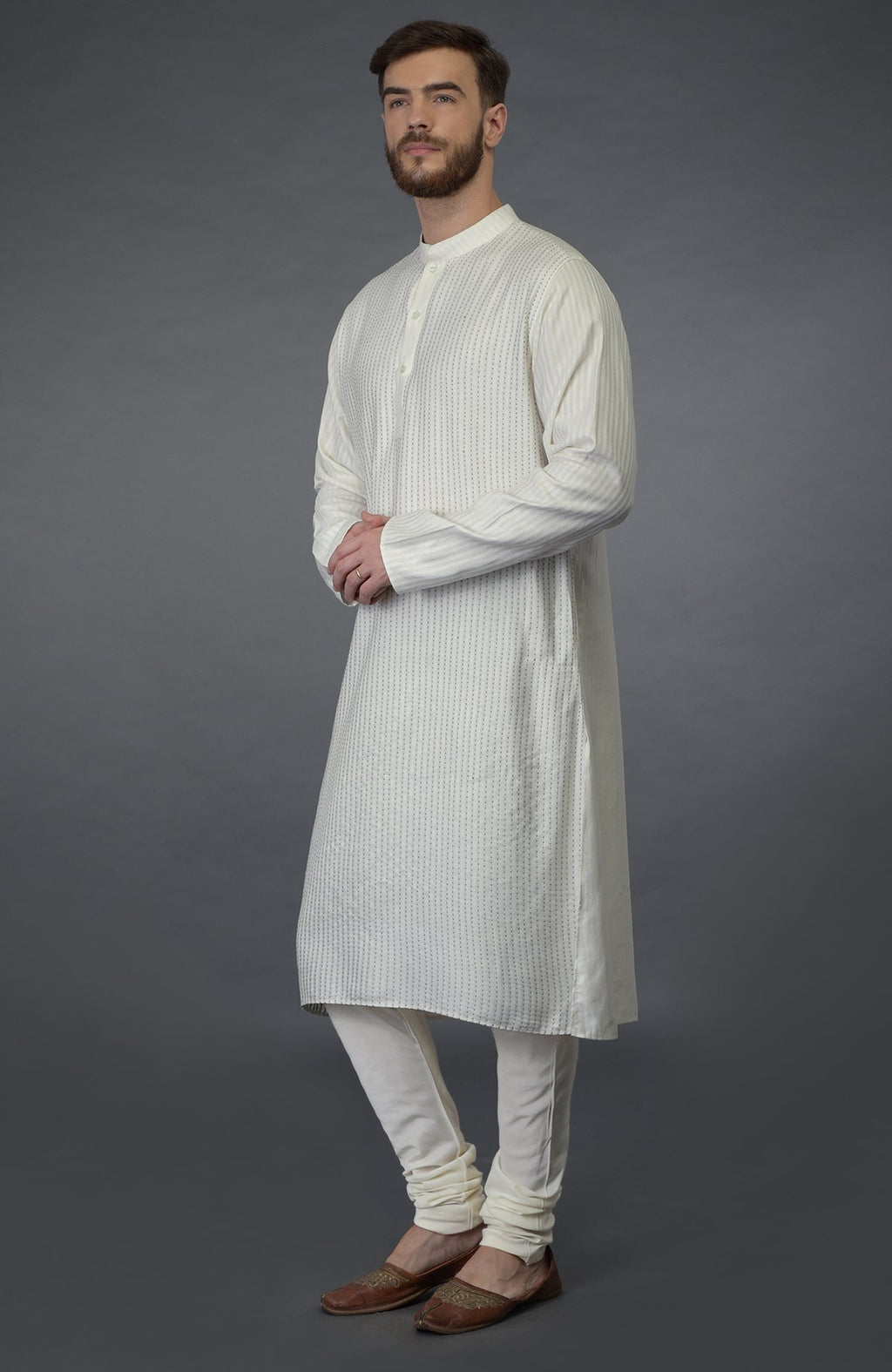 Ivory self weave and black kantha striped silk kurta with matching churidar and juttis.