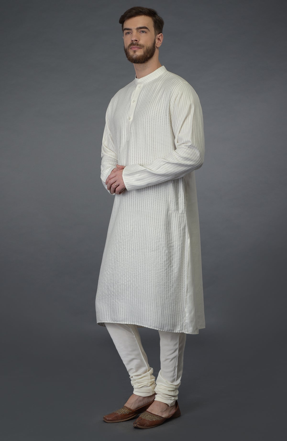 Ivory self weave and black kantha striped silk kurta with matching churidar and juttis.