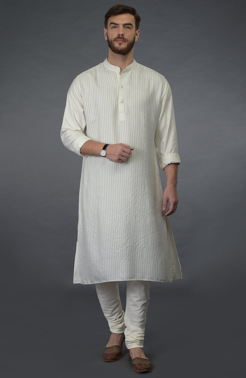 Ivory self weave and black kantha striped silk kurta with matching churidar and brown juttis.