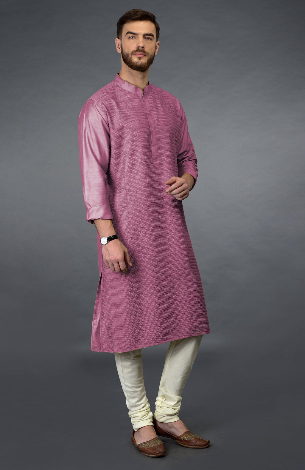 A man models a wine-colored kurta with pintuck detailing and ivory churidars.