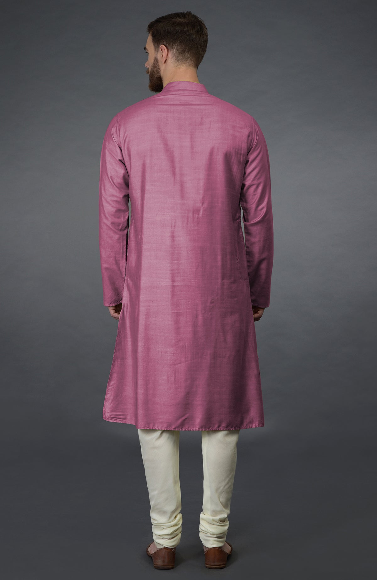 A man from behind wearing a wine-colored kurta and ivory churidar pants.