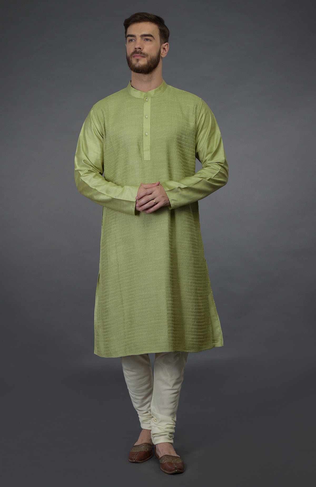 Pista green pintuck silk kurta with a band collar and full sleeves, paired with cream churidar.