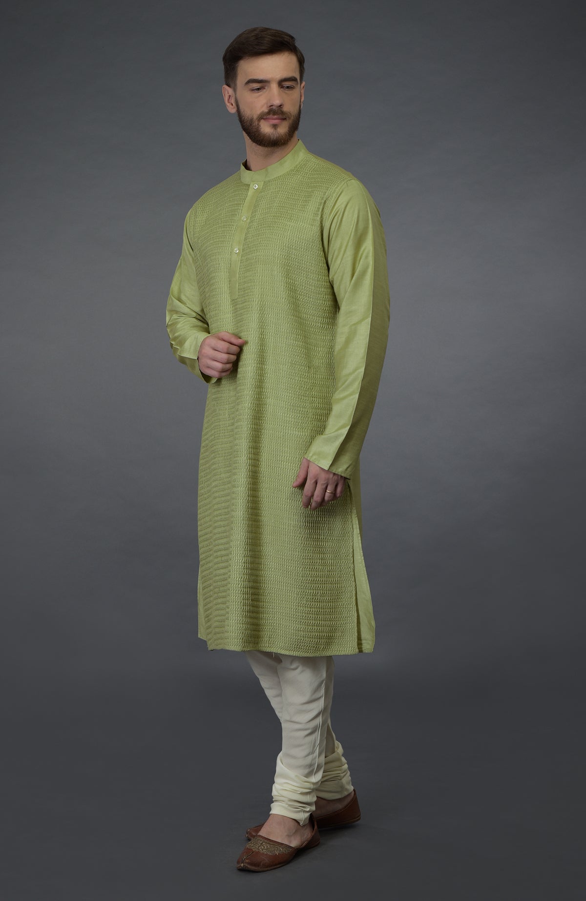 Pista green pintuck silk kurta with white churidar pants and brown juttis.