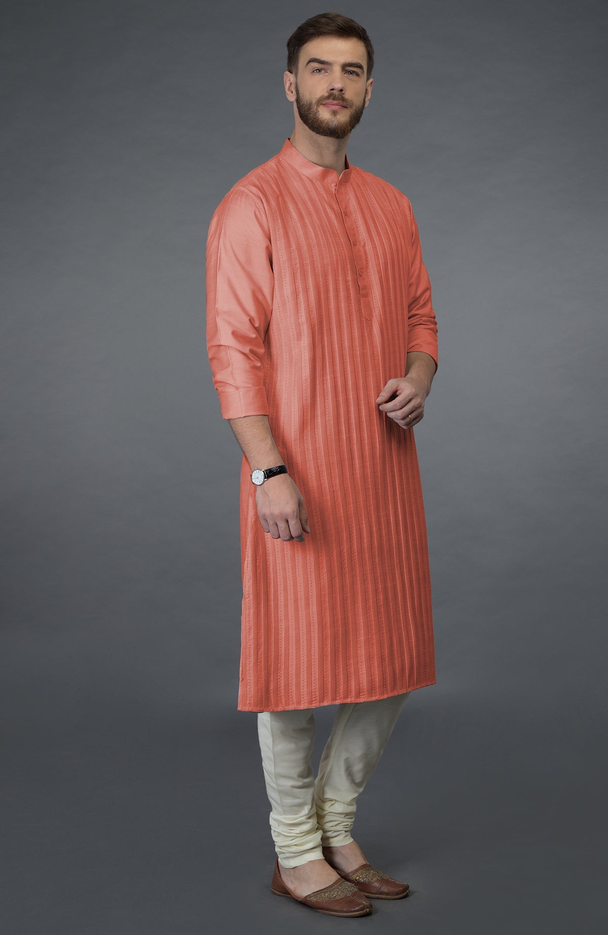 A man models a terracotta pintuck and kantha hand-embroidered kurta set.