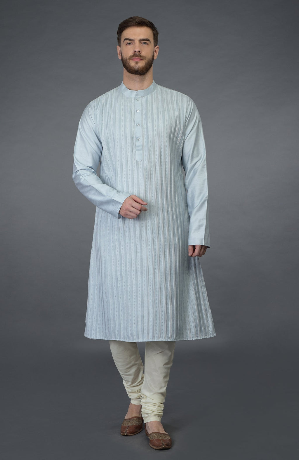 A man in a powder blue pintuck and kantha hand-embroidered kurta set.