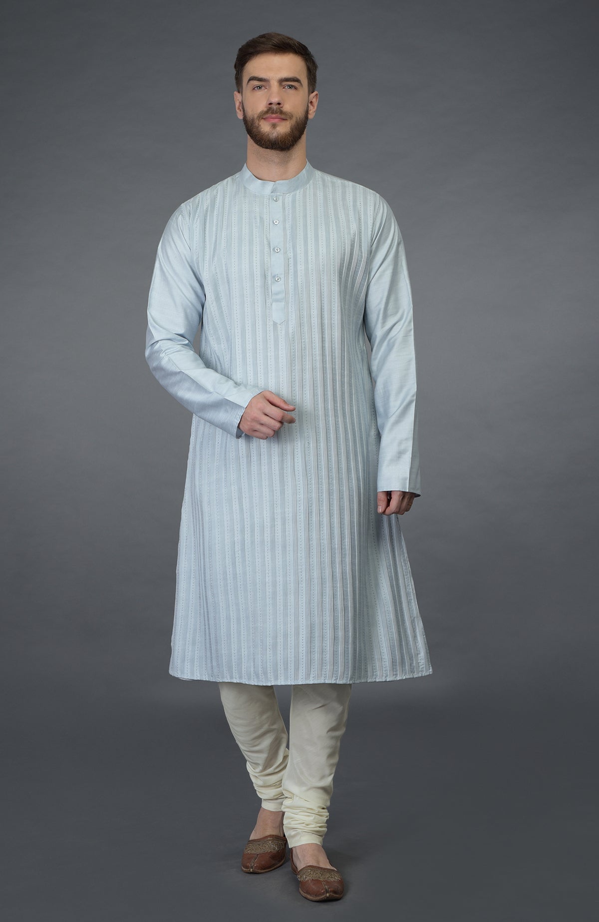 A man in a powder blue pintuck and kantha hand-embroidered kurta set.