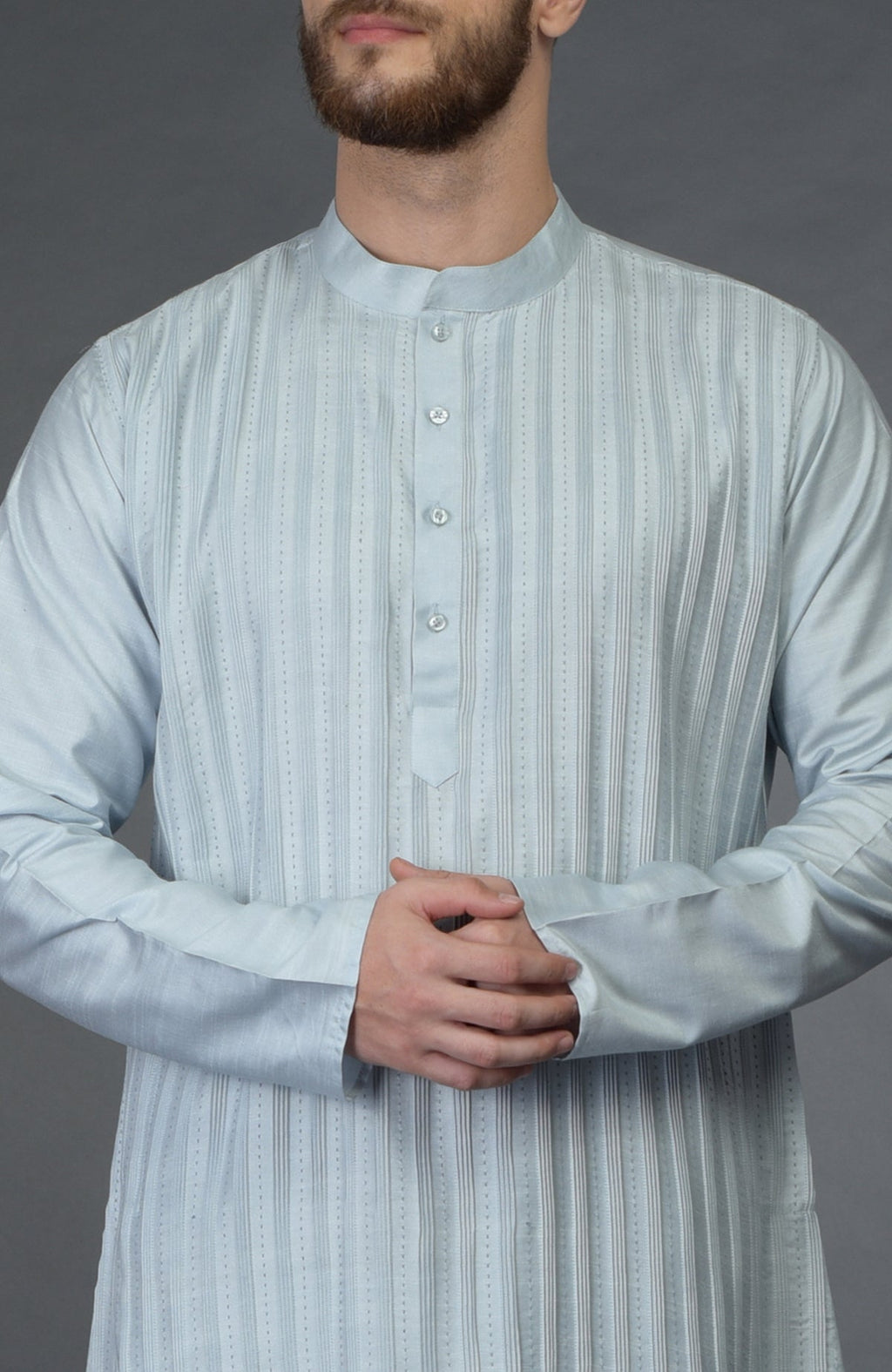 A man in a powder blue pintuck and kantha hand-embroidered kurta.