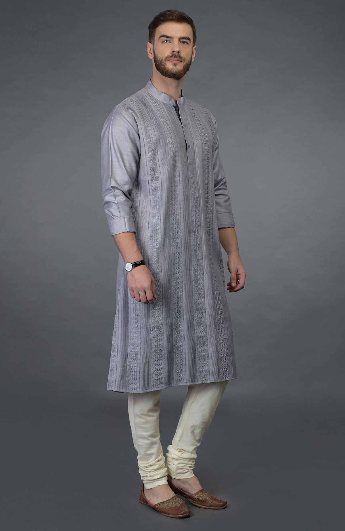 Grey kurta with pintuck detail, ivory churidar, and brown juttis.