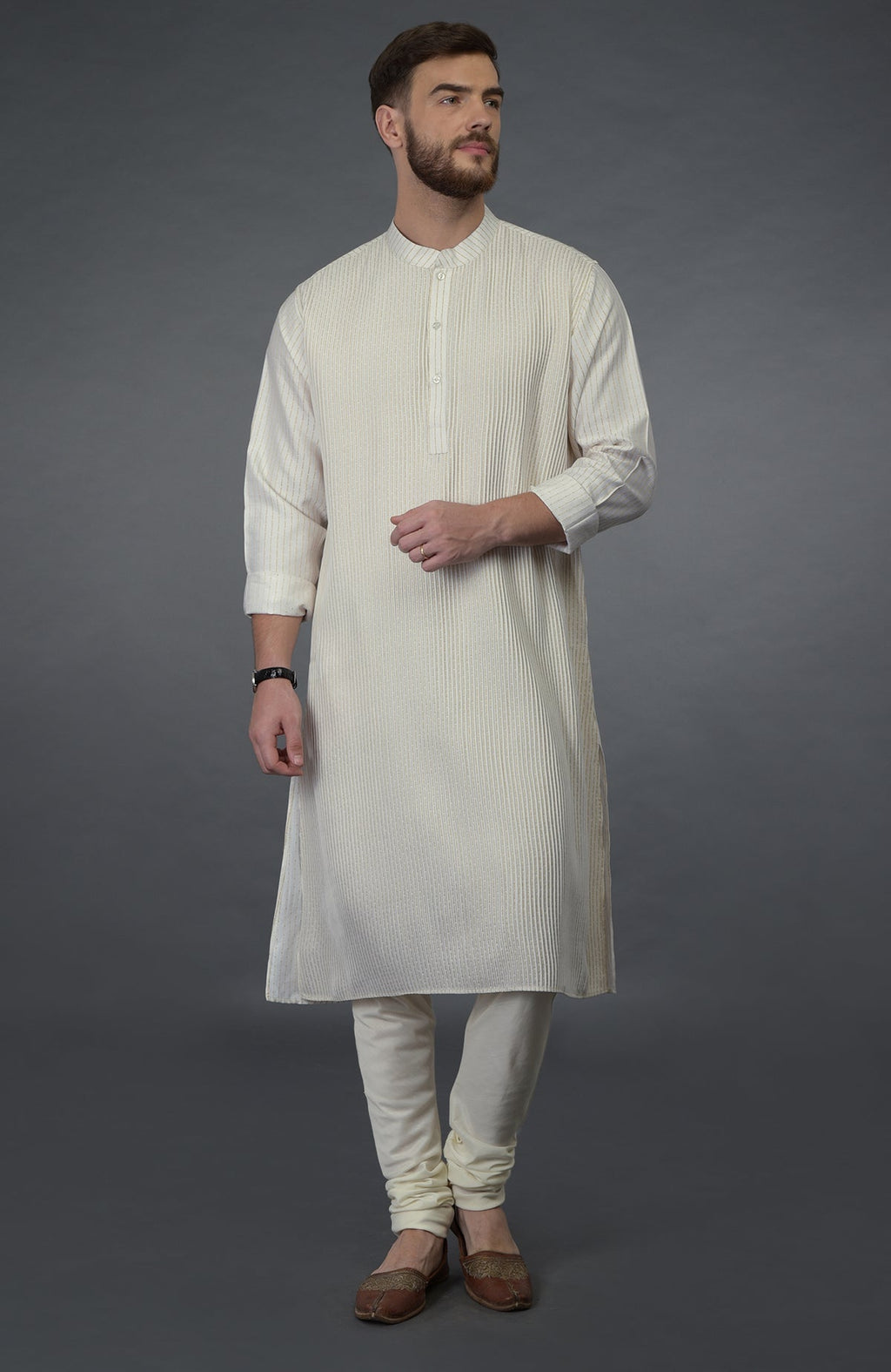 Ivory silk kurta with pintuck detail, paired with matching churidar and brown juttis.