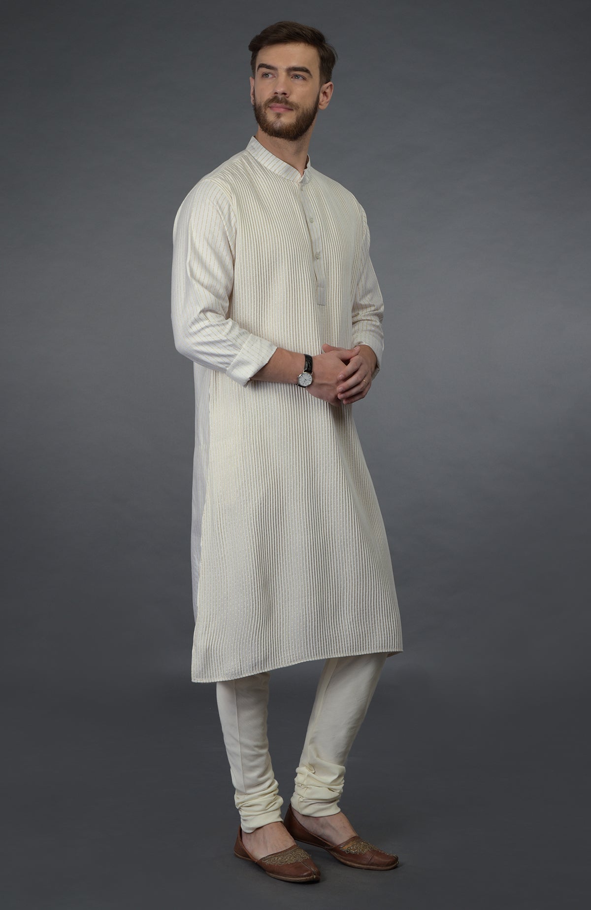 Ivory silk kurta with pintuck detail, paired with matching churidar and brown juttis.