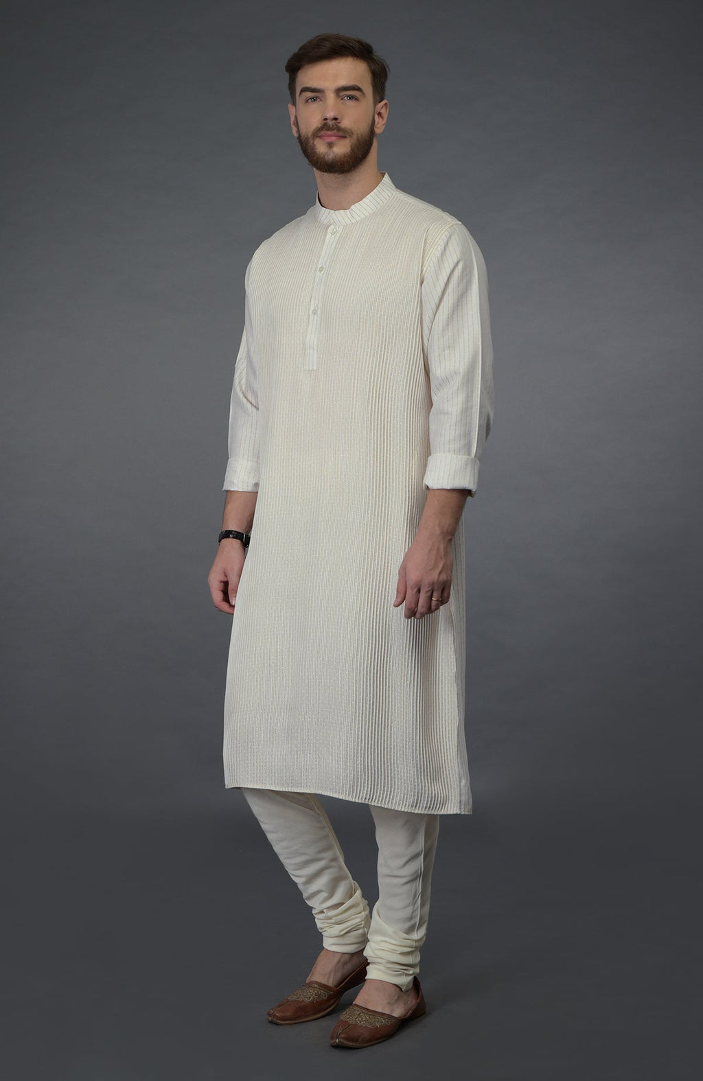 Ivory silk kurta with pintuck detail, paired with matching churidar and brown juttis.
