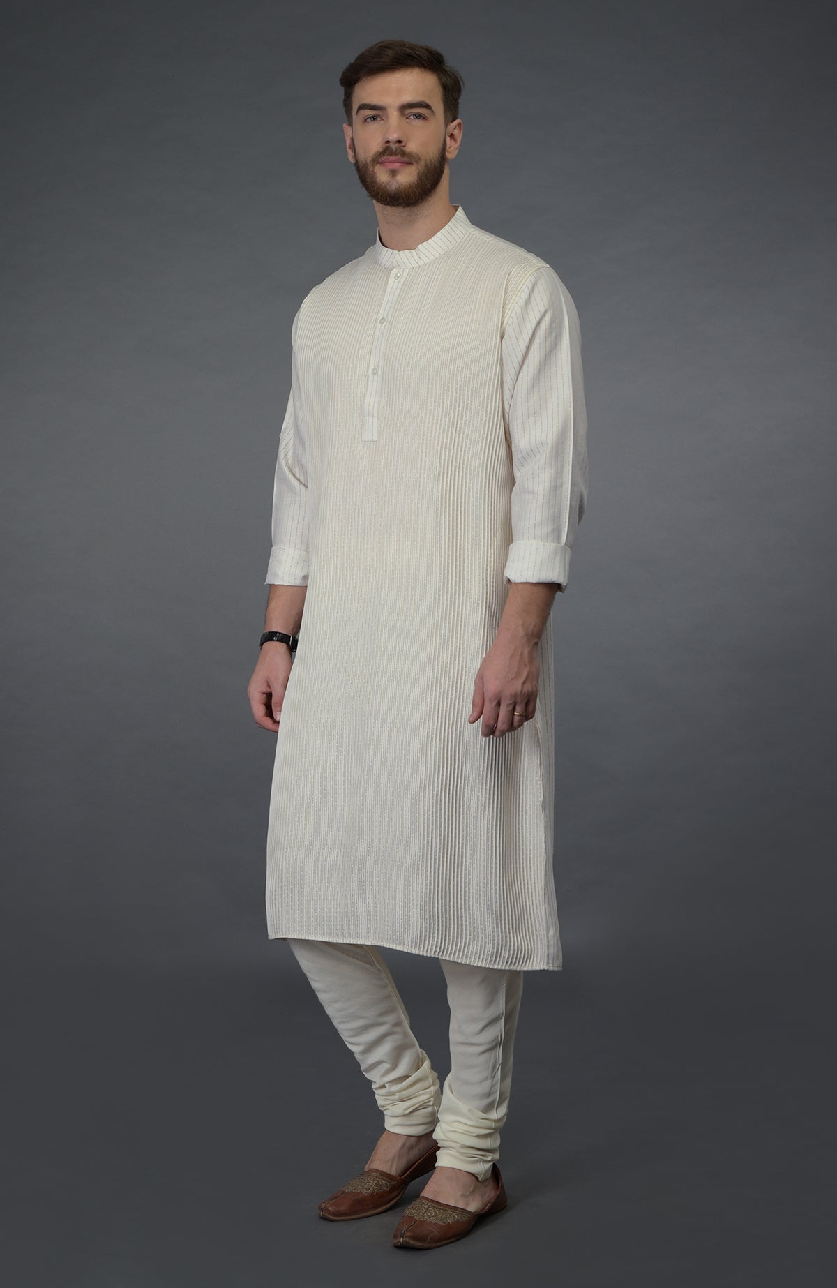 Ivory silk kurta with pintuck detail, paired with matching churidar and brown juttis.