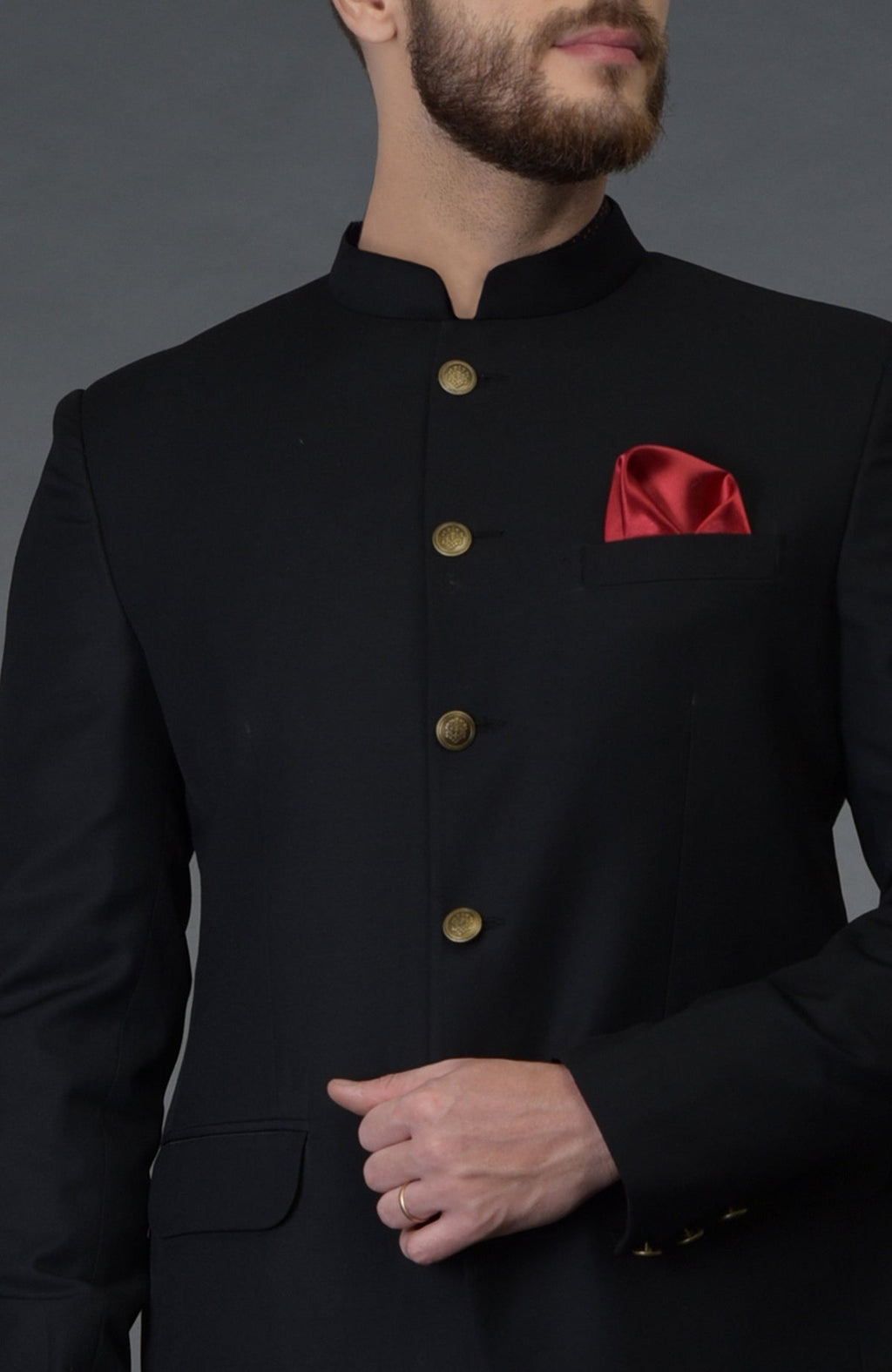 Black pintuck bandhgala jacket with gold buttons and a red pocket square.
