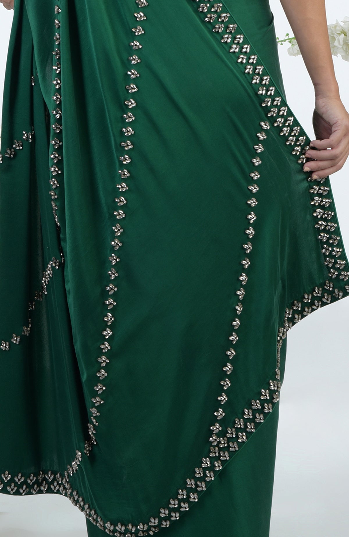 An emerald green saree with crystal hand embroidery.
