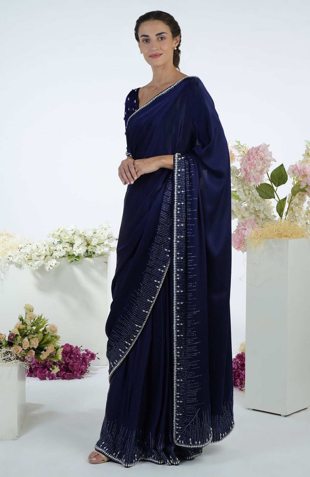 A woman models a midnight blue crystal hand-embroidered saree and blouse.