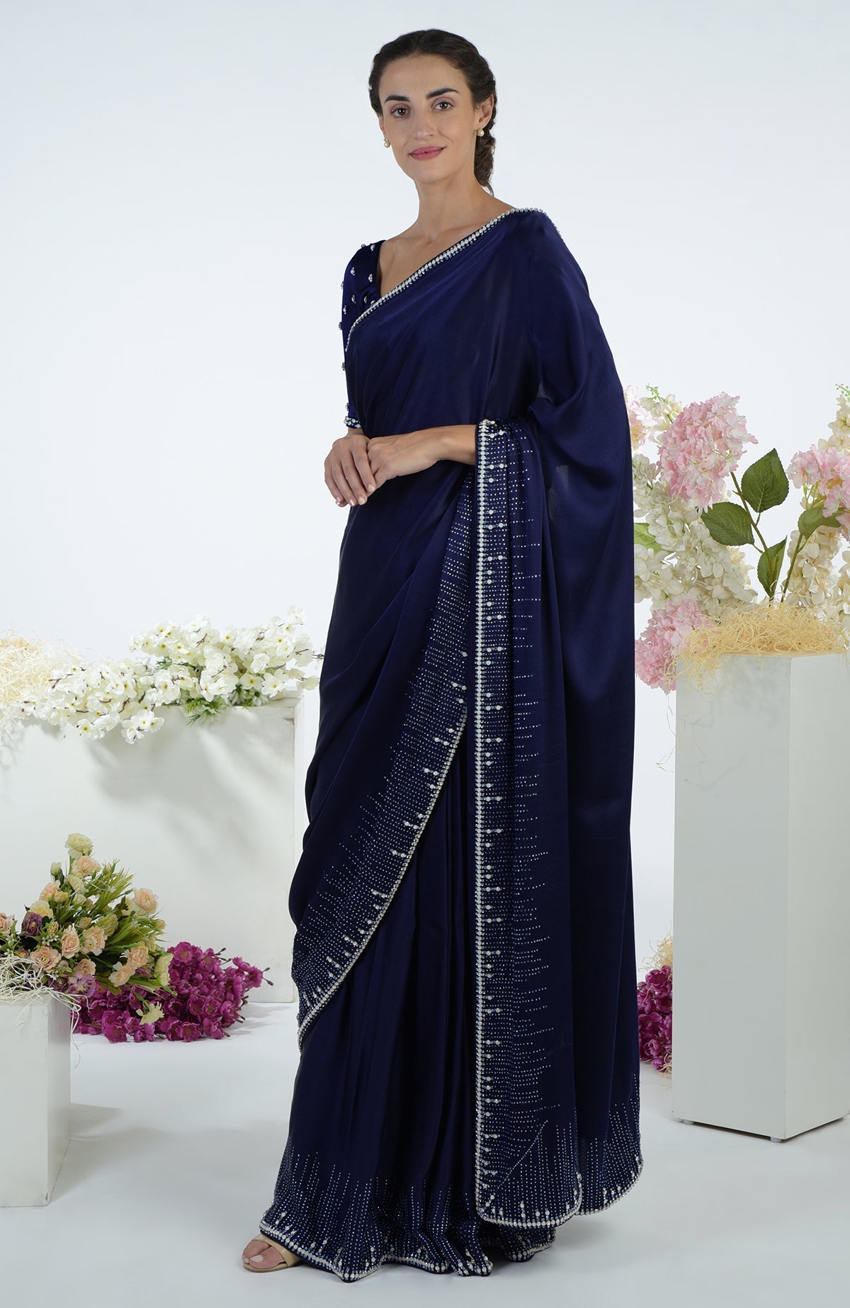 A woman models a midnight blue crystal hand-embroidered saree and blouse.