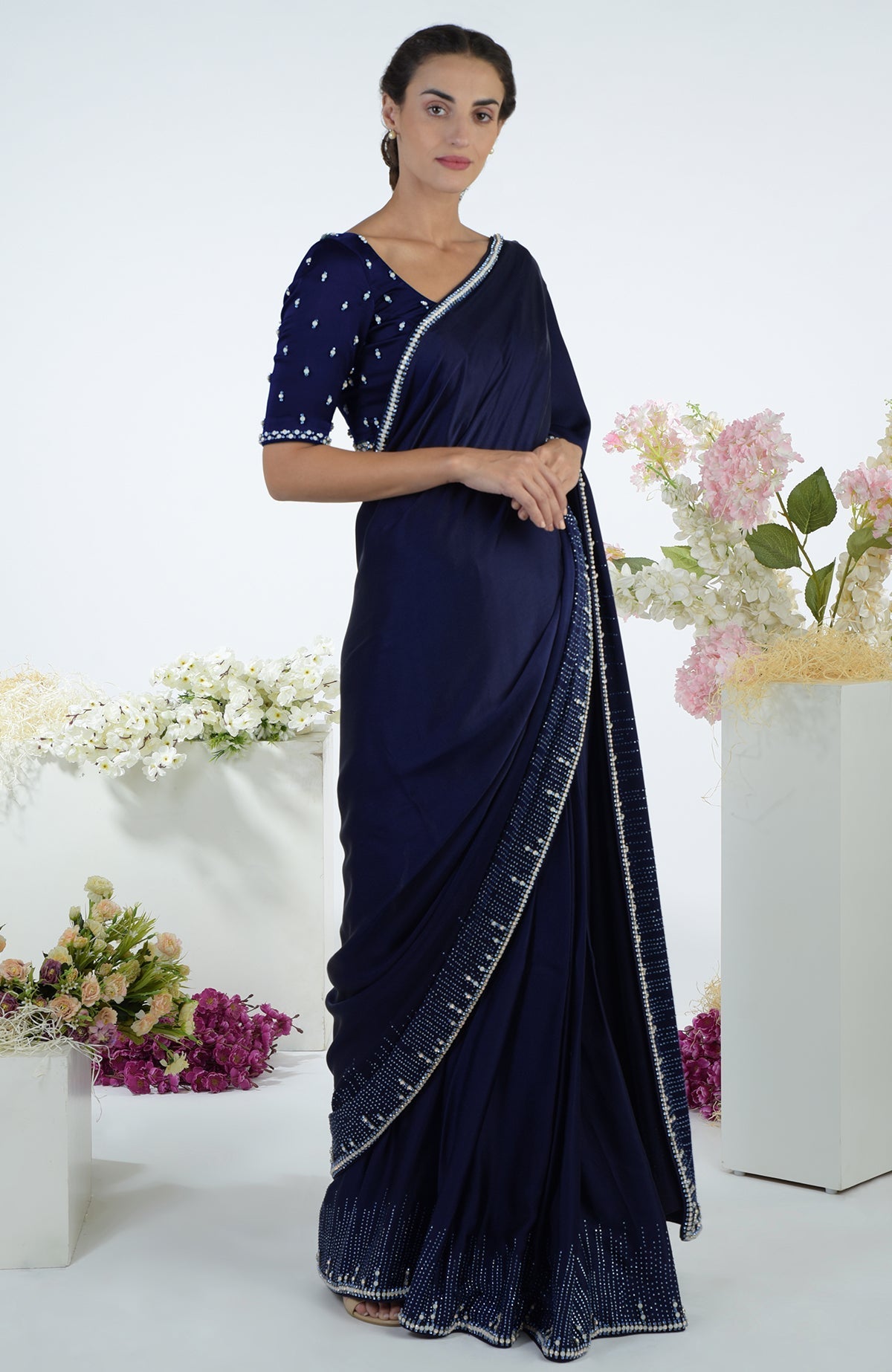 A woman models a midnight blue crystal hand-embroidered saree and blouse.