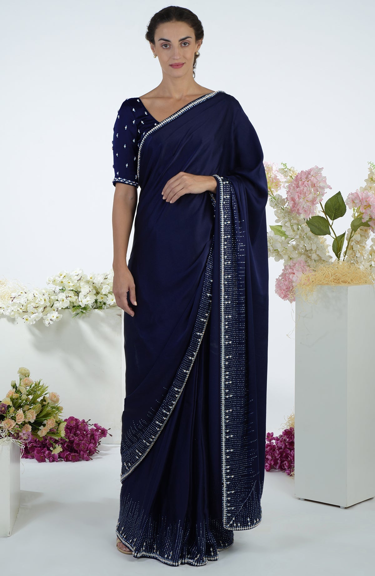 A woman models a midnight blue crystal hand-embroidered saree and blouse.