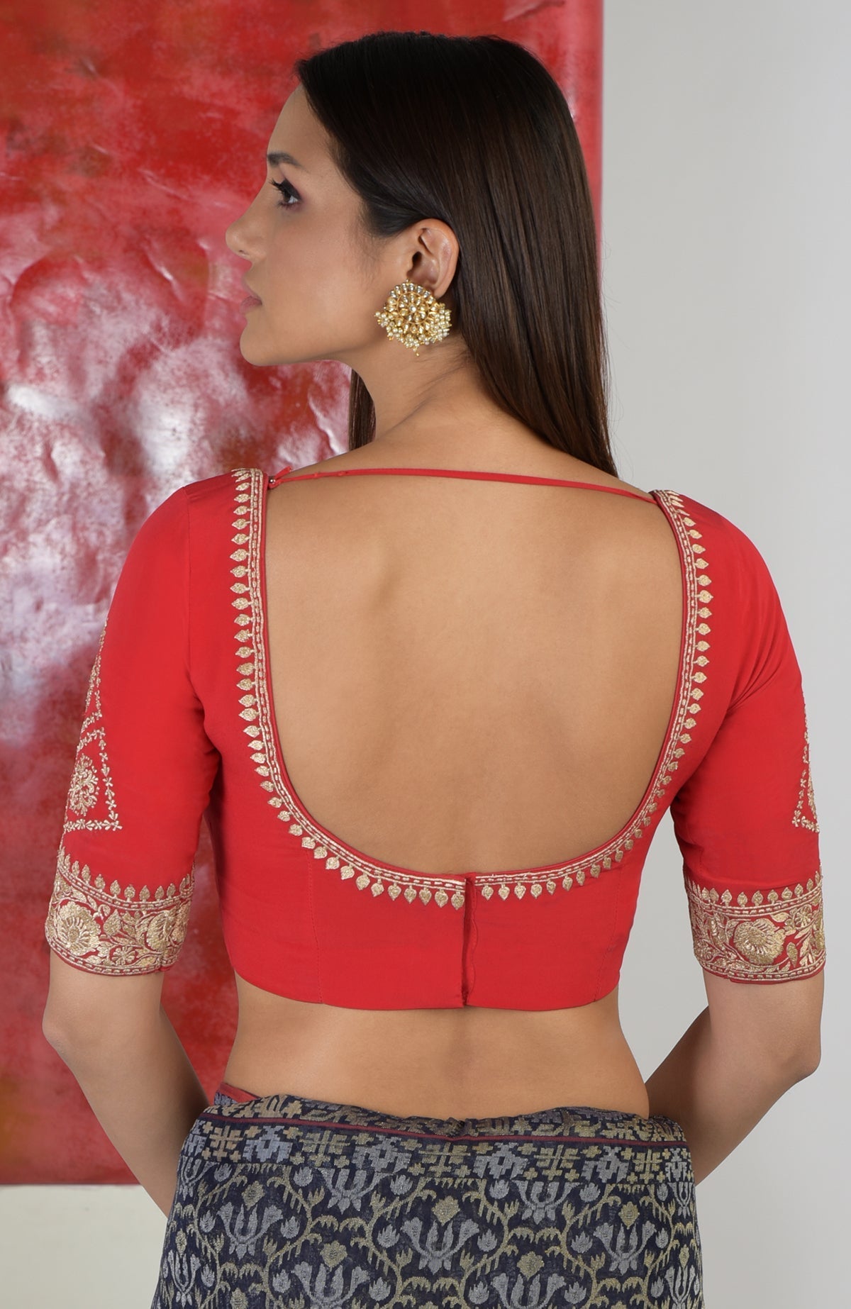 Red zari embroidered sweetheart blouse with a deep back and patterned skirt.