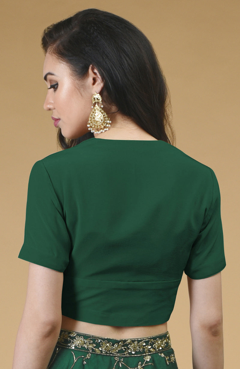 Emerald green V-neck blouse with short sleeves and gold embroidered trim.