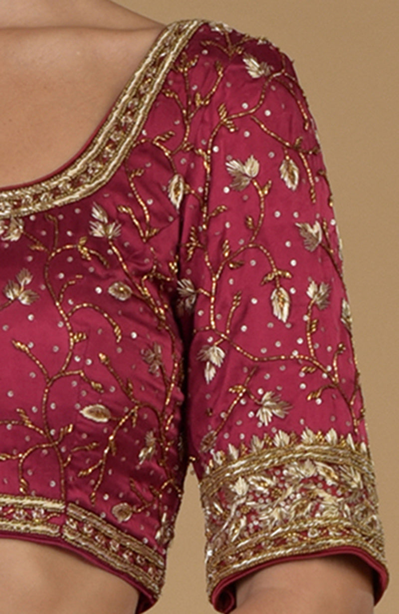Maroon U-neck blouse with intricate gold zardozi and cut-bead embroidery.