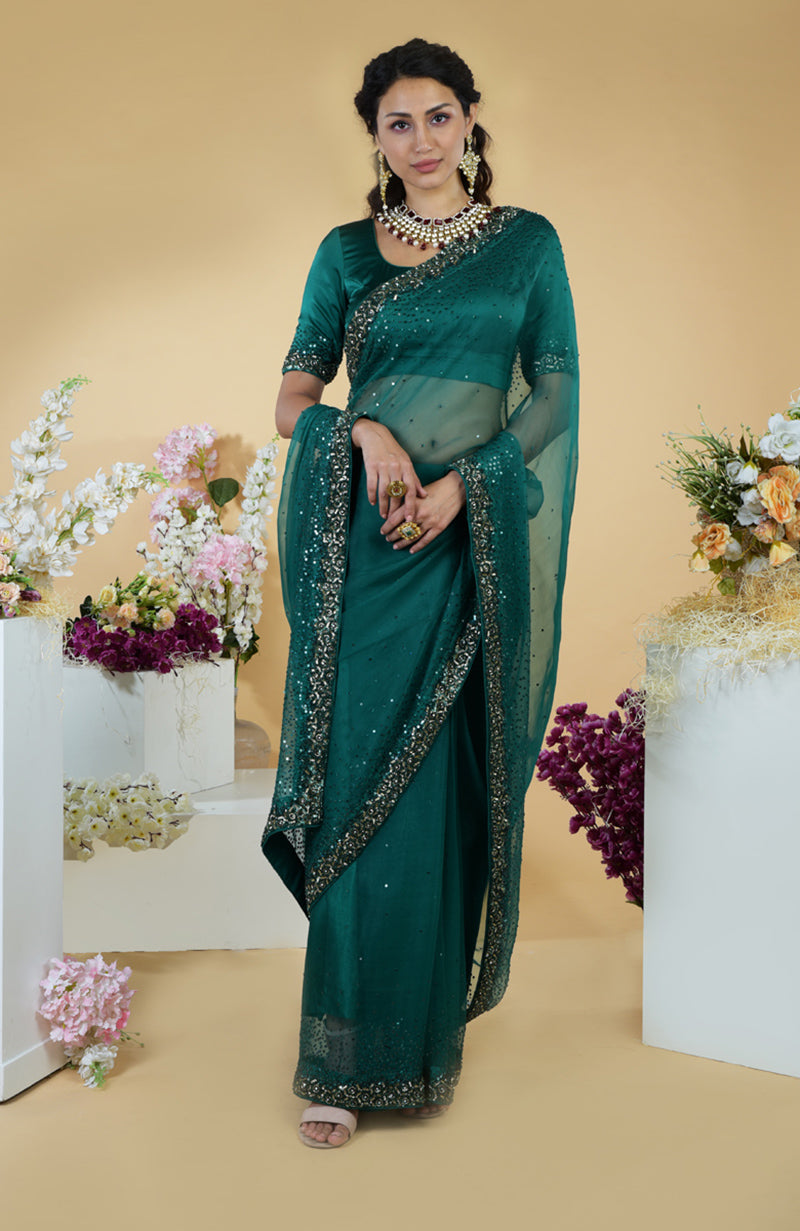 An emerald green organza saree with bead and sequin embroidery.