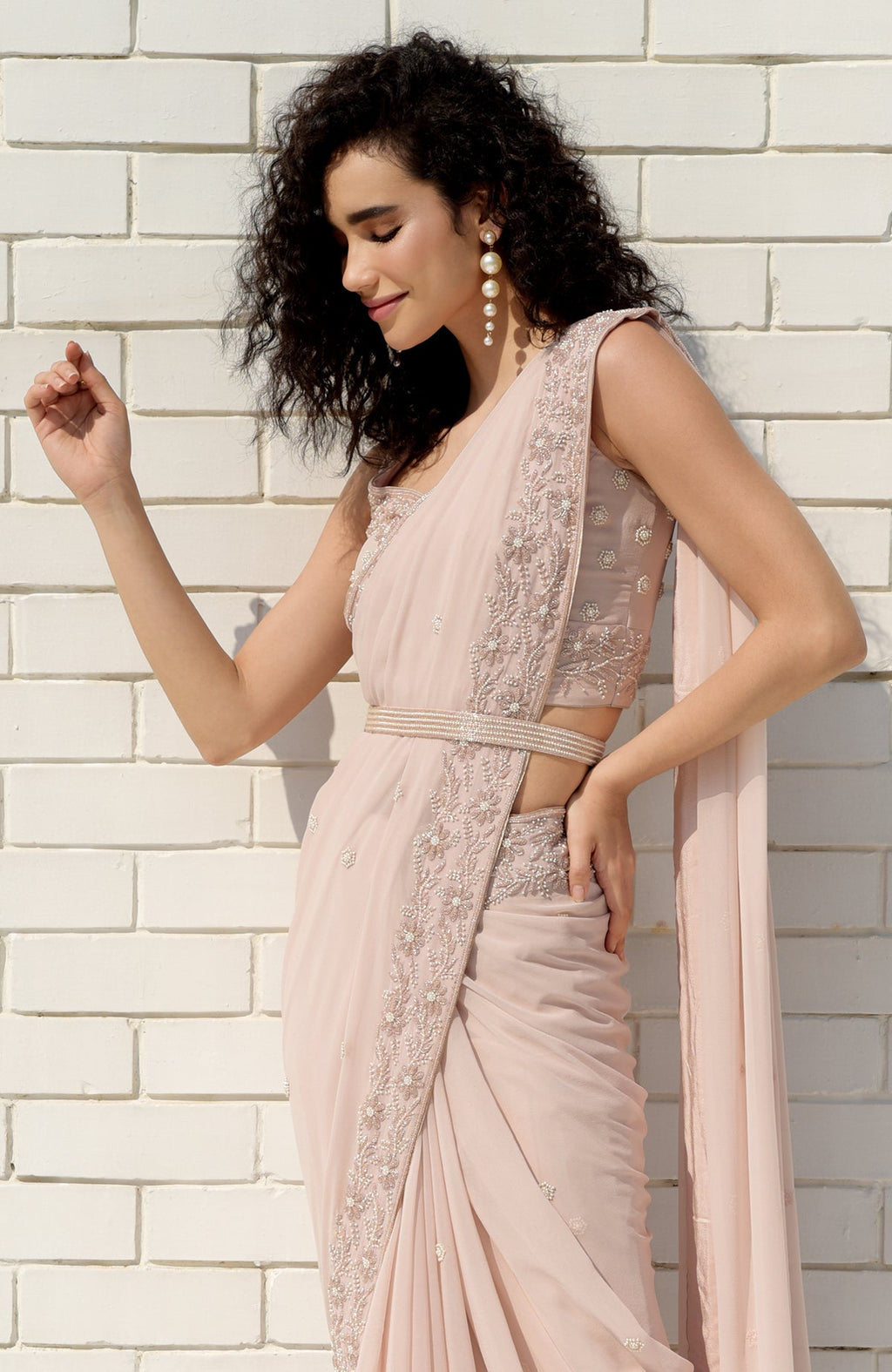 Nude pink saree with hand-embroidered pearl and bead floral designs and matching blouse.