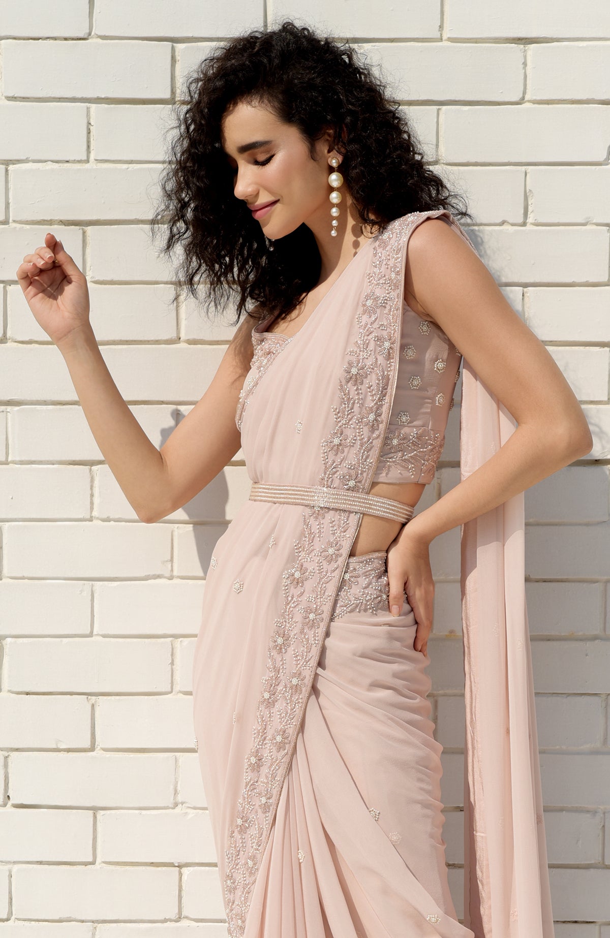 Nude pink saree with hand-embroidered pearl and bead floral designs and matching blouse.