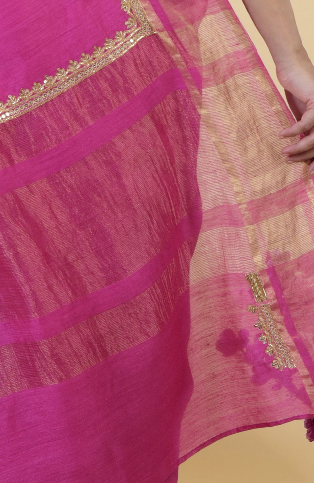 Raspberry linen saree with gold zardozi hand embroidery and striped pallu.
