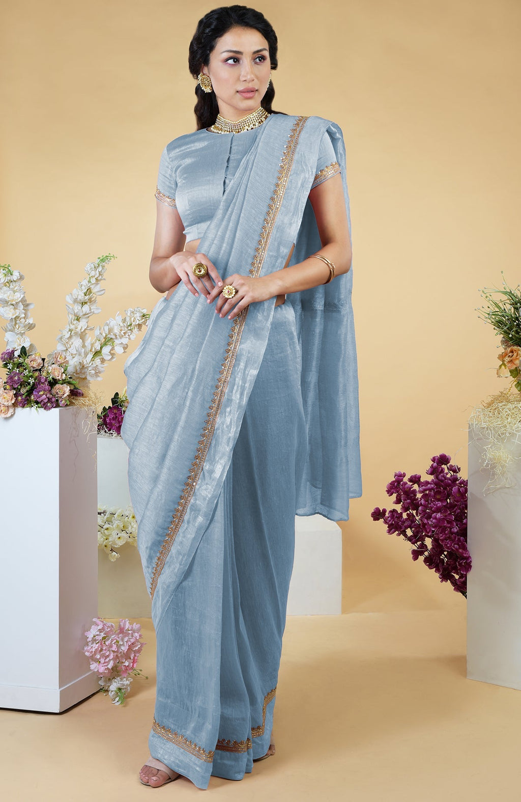 Dusty blue linen saree with hand-embroidered gold zardozi work and matching blouse.
