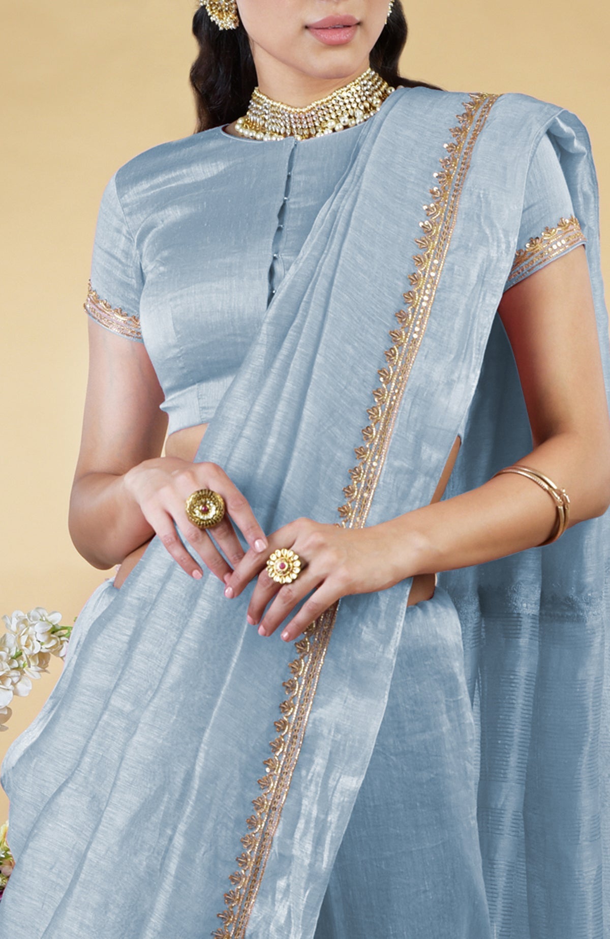 Dusty blue linen saree with gold hand-embroidered zardozi work and matching blouse.