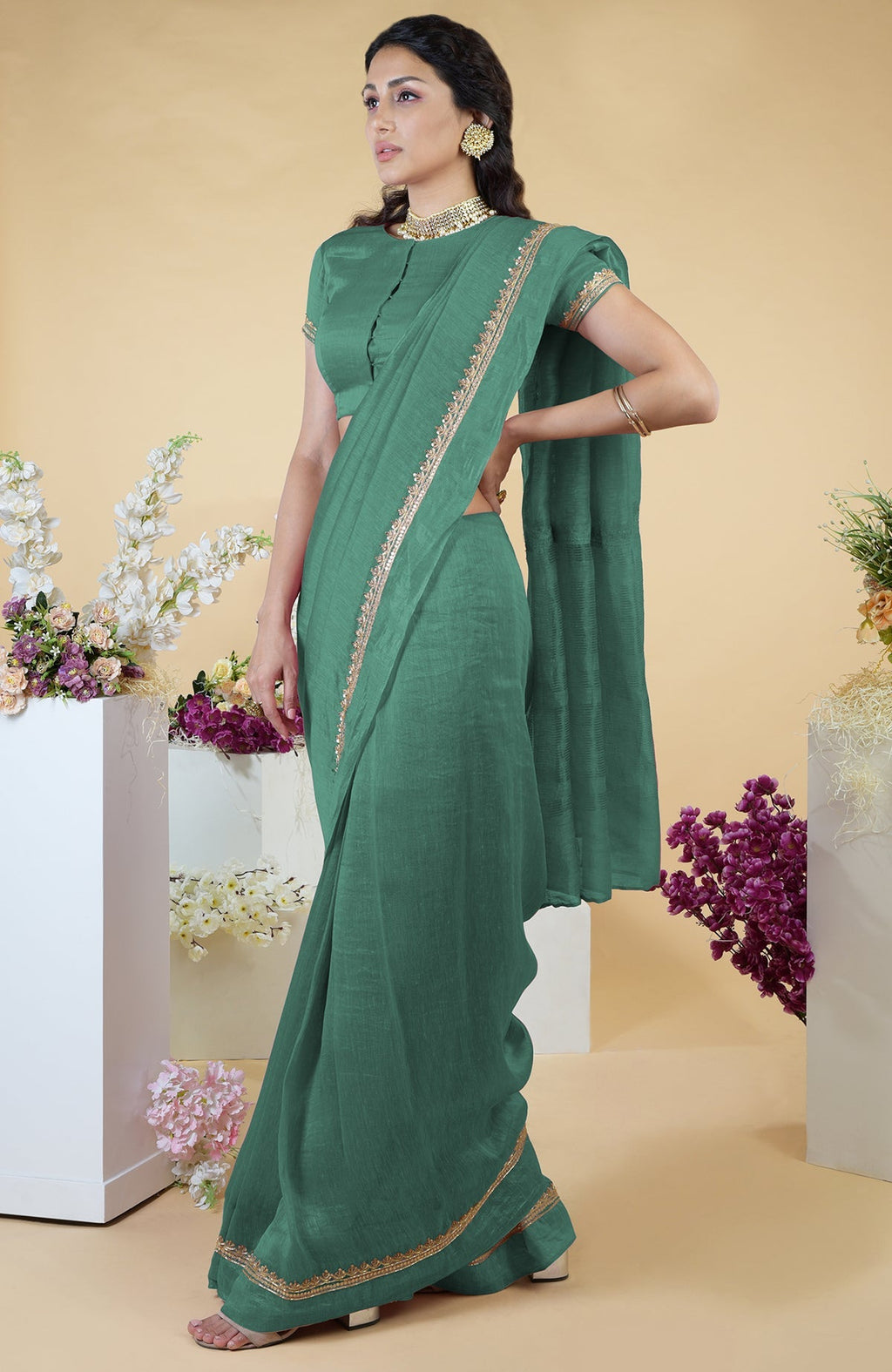 Kale linen saree with hand-embroidered gold zardozi work and matching blouse with jewel neck.
