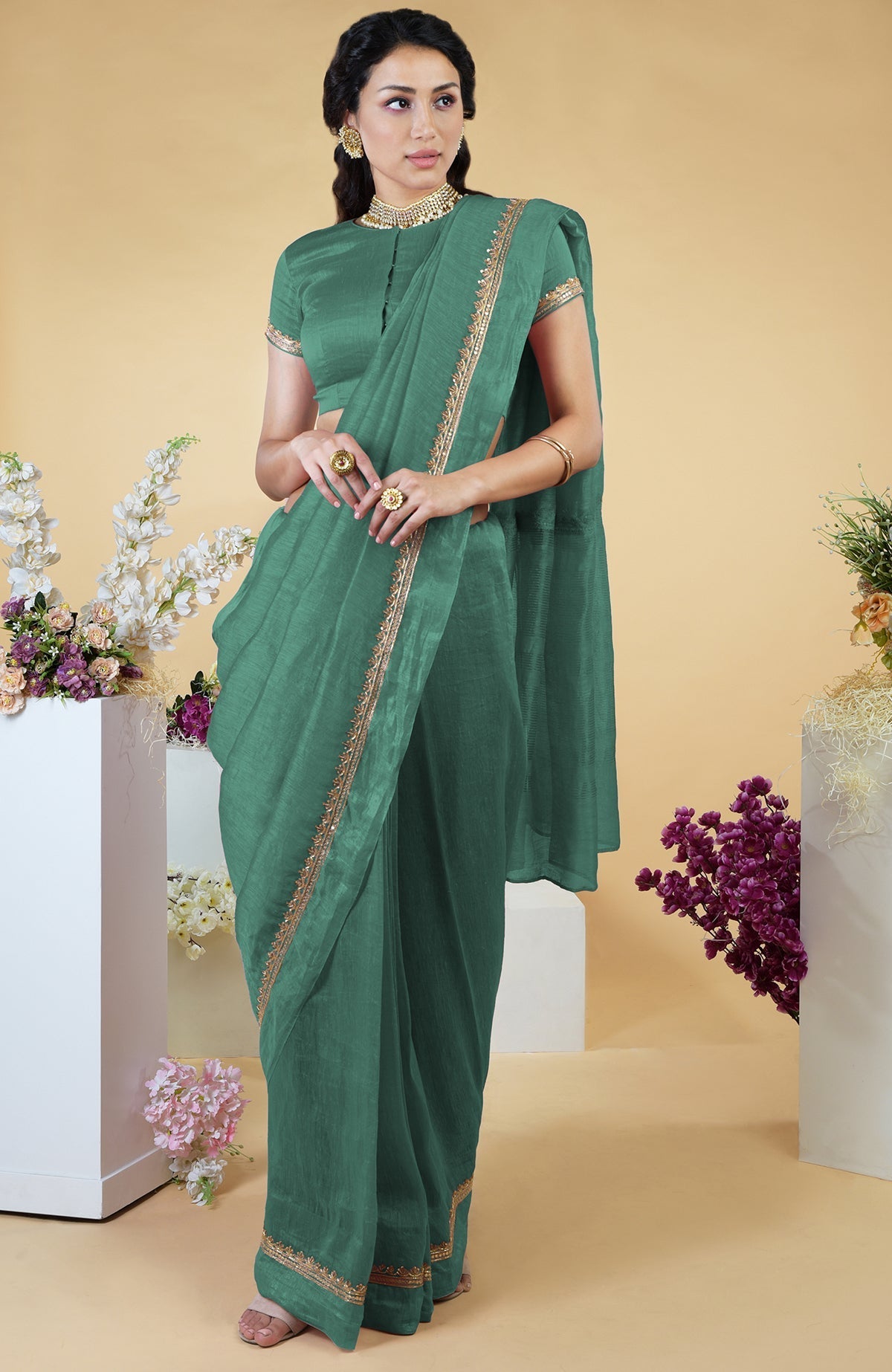 Kale linen saree with hand-embroidered gold zardozi work and matching blouse with jewel neck.