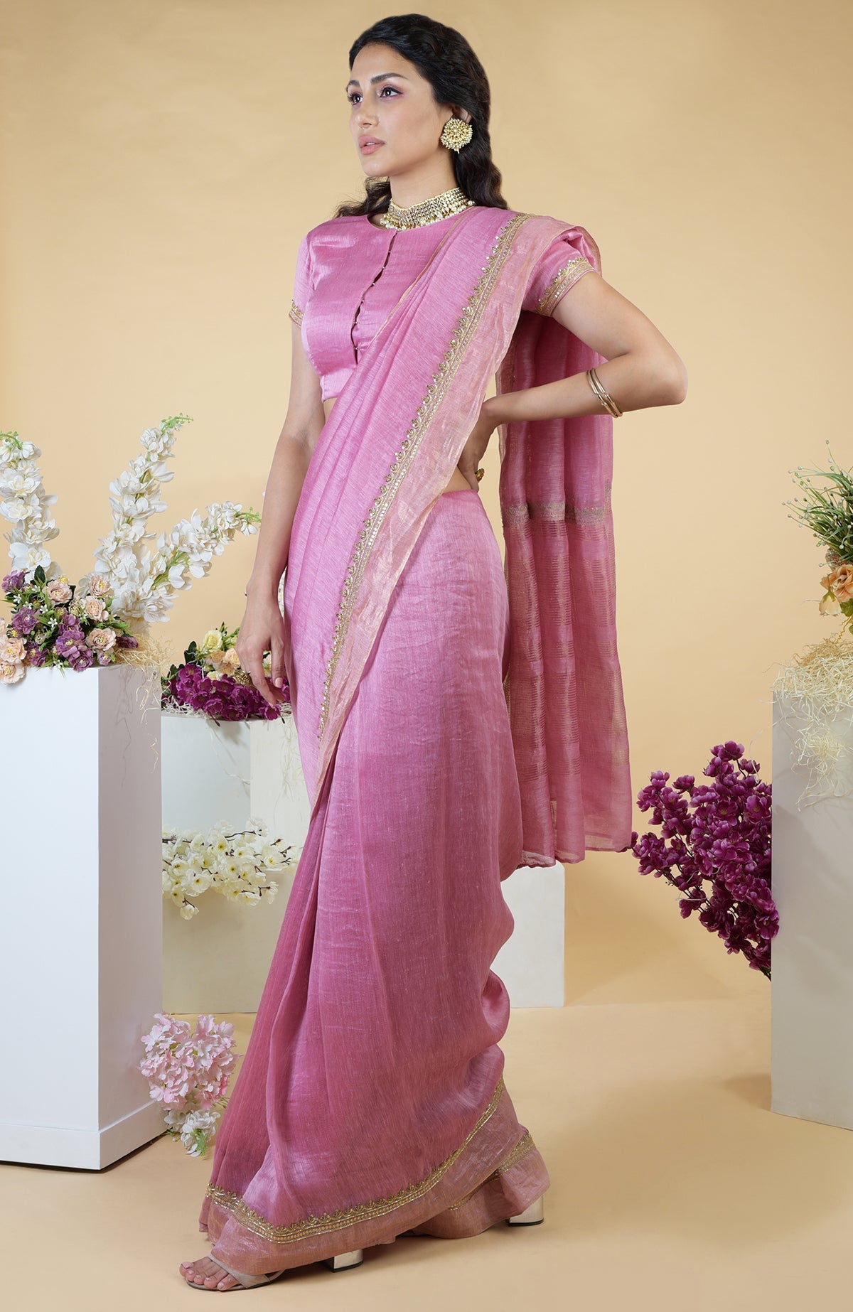 A woman models a withered rose hand-embroidered linen saree with a matching blouse.