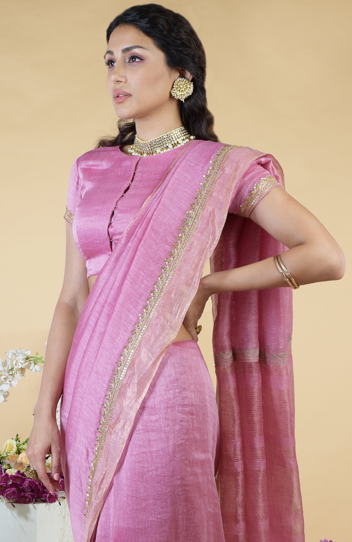 A woman models a withered rose hand-embroidered linen saree with a matching blouse.