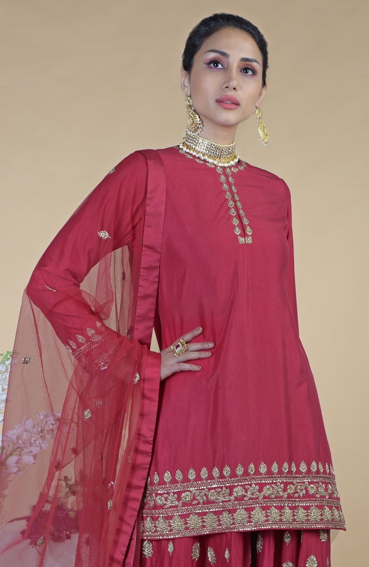 A woman models a crimson-gold zardozi dabka hand-embroidered sharara set.