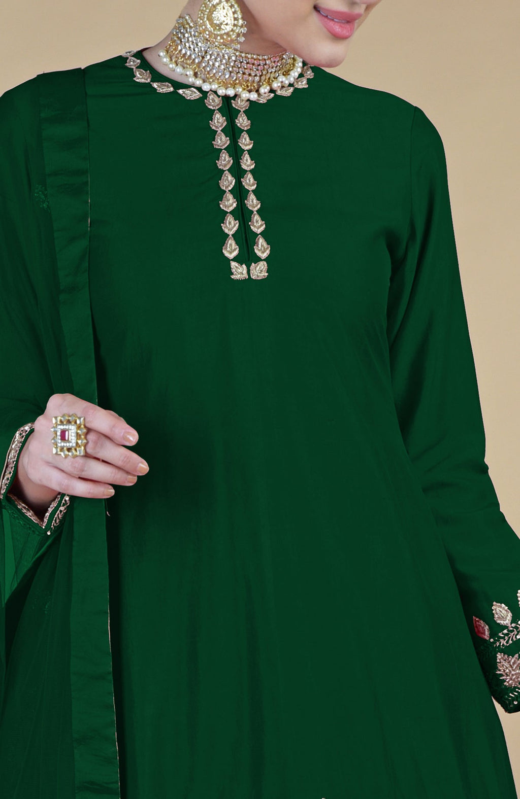 Emerald green salwar suit with gold zardozi embroidery and a pearl choker.