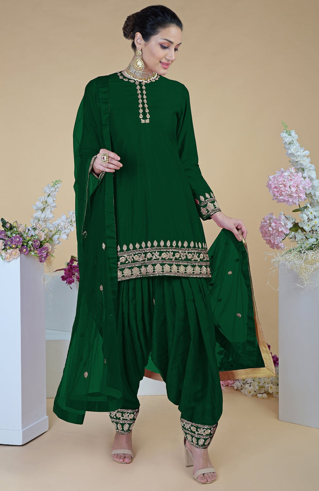 Emerald green salwar suit with gold zardozi embroidery and a sheer dupatta.