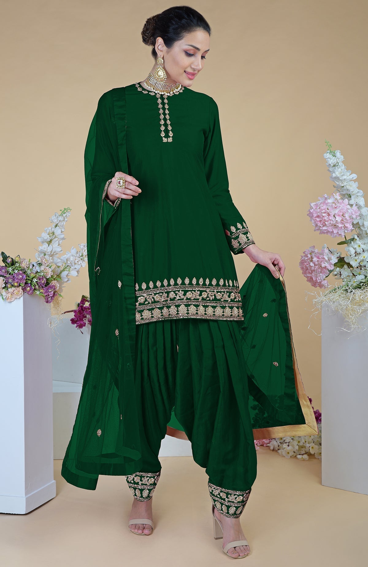 Emerald green salwar suit with gold zardozi embroidery and a sheer dupatta.